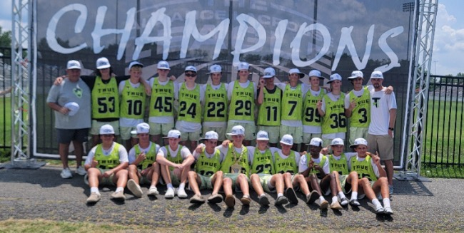 True Long Island team posing together in front of a Champions sign